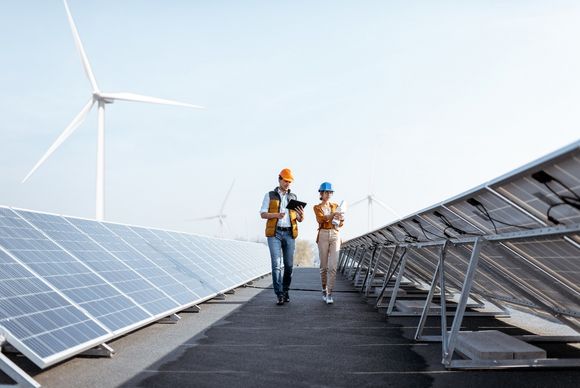 Zwei Ingenieur:innen überprüfen Solaranlage auf einem Dach