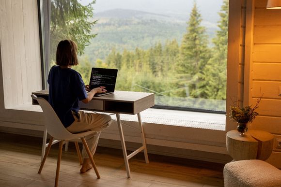 Frau mit Laptop während Workation 