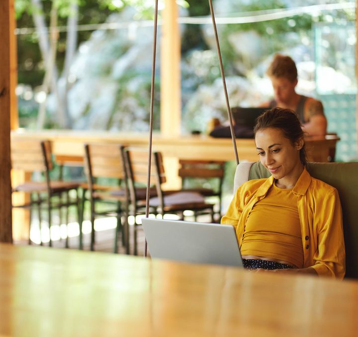 Frau mit Laptop während Workation - Coworking 