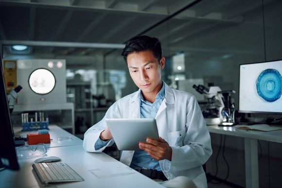 Healthcare-Experte im Labor arbeitet mit Tablet.