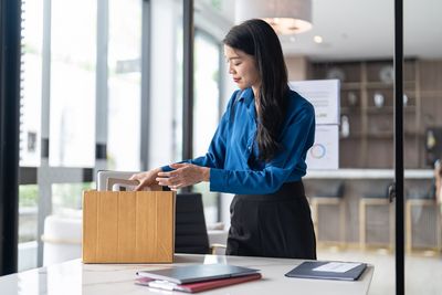 Frau packt nach der Kündigung private Sachen in einen Karton