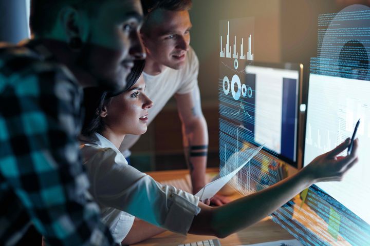 Softwareentwickler diskutieren vor Computer-Screen