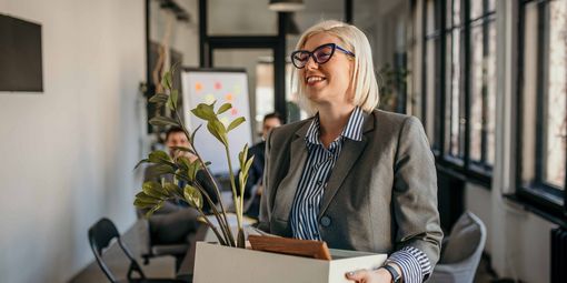 Frau verlässt Büro nach Kündigung ihres Jobs